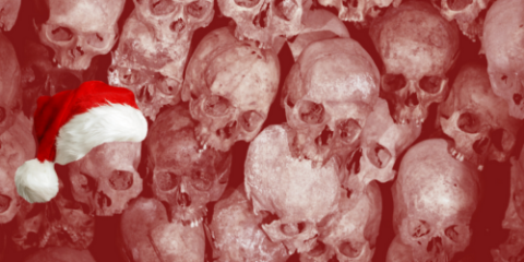 stacks of human skulls, with one in a santa hat